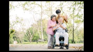 man in a wheelchair surrounded by happy family